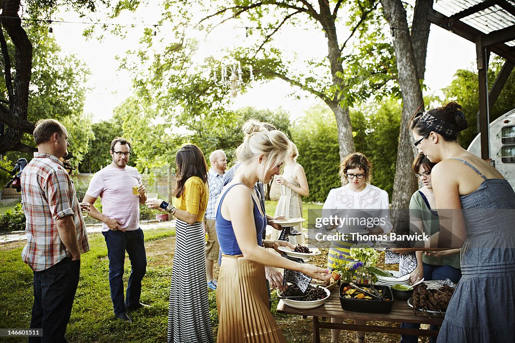 Group of friends in backyard dishing up food