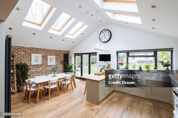 modern kitchen with roof windows, kitchen island and glass doors - home interior stock pictures, royalty-free photos & images