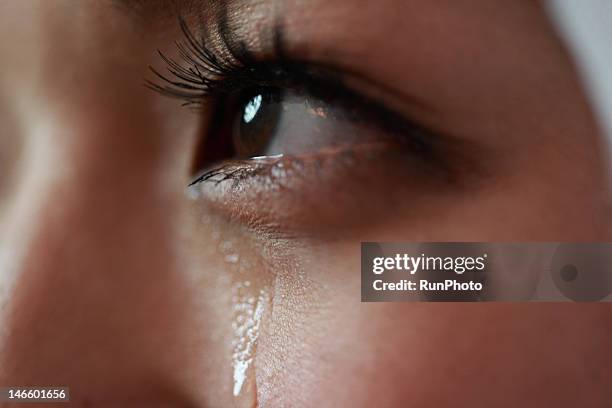 young woman with tear rolling down cheek - mood photos et images de collection