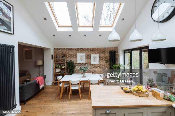 modern kitchen with roof windows, kitchen island and glass doors - kitchen window stock pictures, royalty-free photos & images