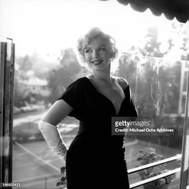 Actress Marilyn Monroe attends a party held in her honor wearing a black dress and white gloves at the Beverly Hills Hotel on July 8, 1958 in Beverly...