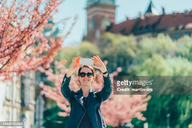 smiling woman at the street in krakow taking selfie - wawel cathedral stock pictures, royalty-free photos & images