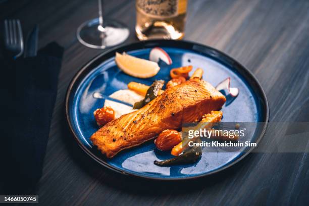 salmon steak served on a blue plate - lachs stock-fotos und bilder