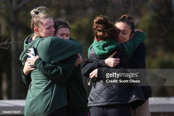 People leave flowers, mourn and pray at a makeshift memorial at the Spartan statue on the campus Michigan State University on February 14, 2023 in...