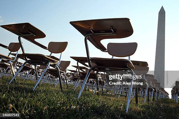 An installation of 857 empty school desks, representing the number of students nationwide who are dropping out every hour of every school day, is on...