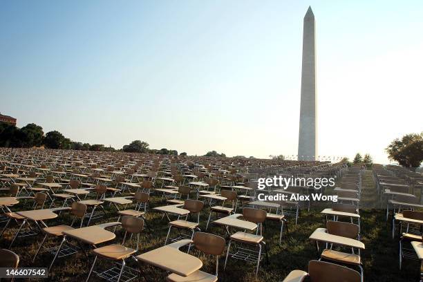 An installation of 857 empty school desks, representing the number of students nationwide who are dropping out every hour of every school day, is on...