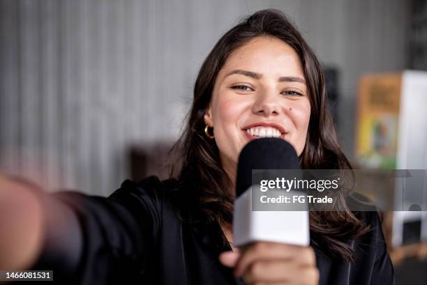 repórter falando ao microfone em um armazém - ponto de vista - apresentador de noticiário - fotografias e filmes do acervo