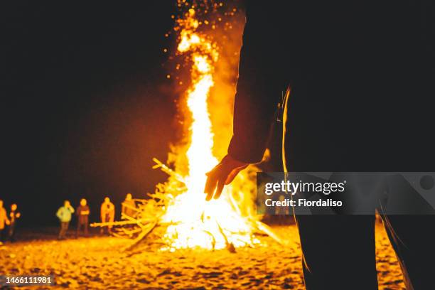 big bonfire in the night, flames of fire, sparks. rituals, circle magic, round dance, selective focus - bon fire foto e immagini stock