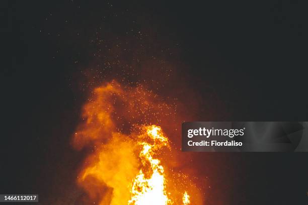 big bonfire in the night, flames of fire, sparks. rituals, circle magic, round dance, selective focus - cremation stockfoto's en -beelden