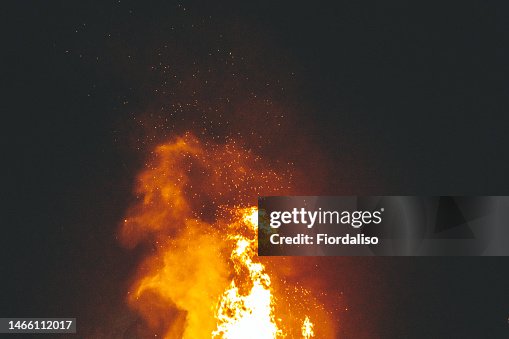 Big bonfire in the night, flames of fire, sparks. Rituals, circle magic, round dance, selective focus