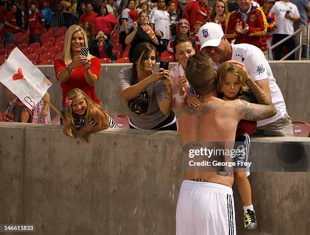 Three year old Kai Raider is given a jersey and a hug by David Beckham of Los Angeles Galaxy after a game with Real Salt Lake during the second half...