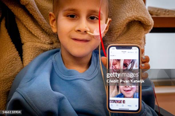 Girl shows her selfie with Queen Maxima of The Netherlands during her visit to the Princess Maxima Center for Pediatric Oncology on February 14, 2023...