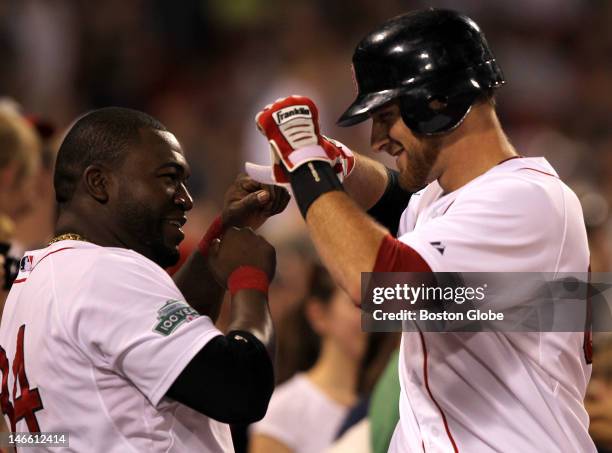 Boston Red Sox third baseman Will Middlebrooks is congratulated in the Sox dugout by Boston Red Sox designated hitter David Ortiz after his two run...