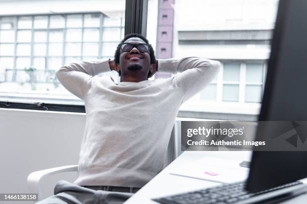 happy afro-american businessman stretching at desk - stretching at work stock pictures, royalty-free photos & images