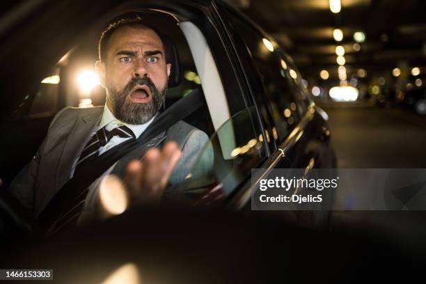 angry mid aged man driving his car and shouting at other drivers. - road rage stock pictures, royalty-free photos & images