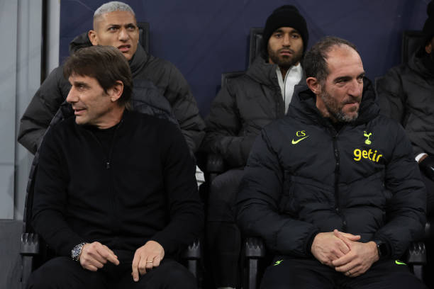 Antonio Conte Head coach of Tottenham and Cristian Stellini Assistant coach of Tottenham look in opposite directions as they sit on the bench prior...