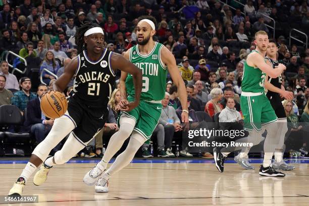 Jrue Holiday of the Milwaukee Bucks drives around Derrick White of the Boston Celtics during the first half of a game at Fiserv Forum on February 14,...