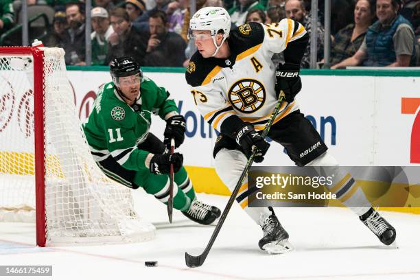 Charlie McAvoy of the Boston Bruins skates with the puck in front of Luke Glendening of the Dallas Stars during the first period at American Airlines...