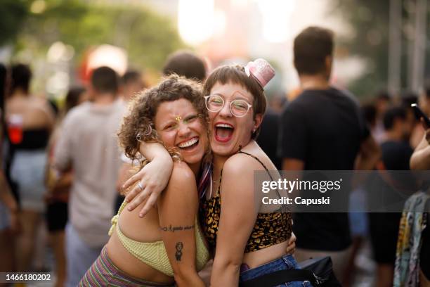 happy friends embracing each other while having fun at a carnival party - traditional festival stock pictures, royalty-free photos & images