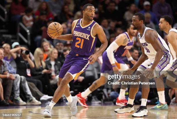 Warren of the Phoenix Suns handles the ball against Harrison Barnes of the Sacramento Kings during the first half of the NBA game at Footprint Center...