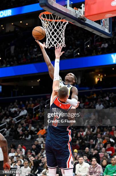 Bennedict Mathurin of the Indiana Pacers drives to the basket against Kristaps Porzingis of the Washington Wizards at Capital One Arena on February...