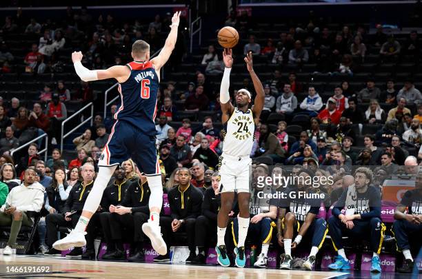 Buddy Hield of the Indiana Pacers shoots the ball against Kristaps Porzingis of the Washington Wizards at Capital One Arena on February 11, 2023 in...