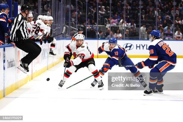 Erik Brannstrom of the Ottawa Senators and Mathew Barzal of the New York Islanders battle for the puckduring their game at UBS Arena on February 14,...