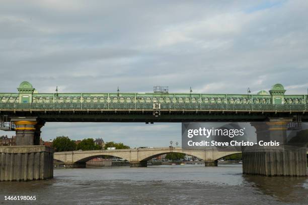 Fulham Railway bridge with Putney Bridge in the distance on the River Thames on August 29, 2022 in London, United Kingdom.