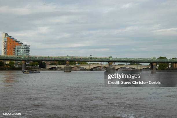 Fulham Railway bridge with Putney Bridge in the distance on the River Thames on August 29, 2022 in London, United Kingdom.