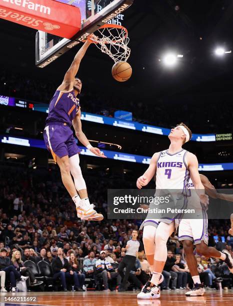 Devin Booker of the Phoenix Suns slam dunks the ball over Kevin Huerter of the Sacramento Kings during the second half of the NBA game at Footprint...