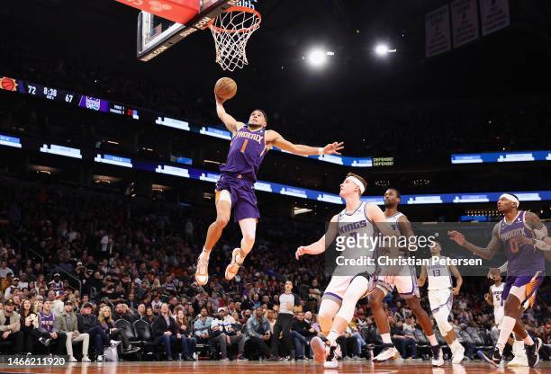 Devin Booker of the Phoenix Suns slam dunks the ball over Kevin Huerter of the Sacramento Kings during the second half of the NBA game at Footprint...