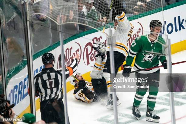 David Pastrnak of the Boston Bruins slips on the ice while celebrating after scoring a goal during overtime against the Dallas Stars at American...