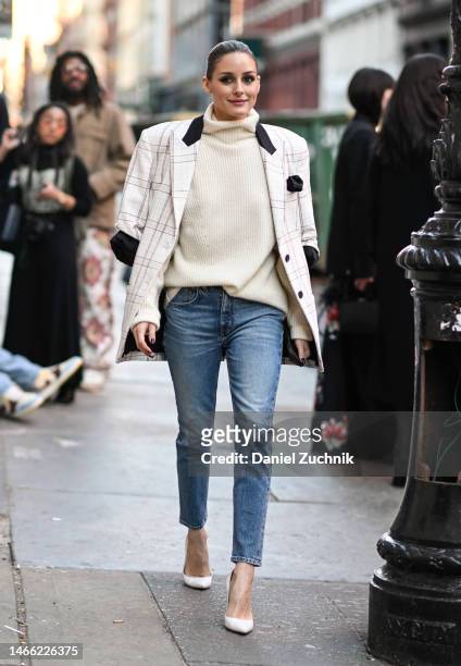 Olivia Palermo is seen wearing a black and white checkered jacket, cream sweater, blue jeans and white heels outside the Hellessy show during New...