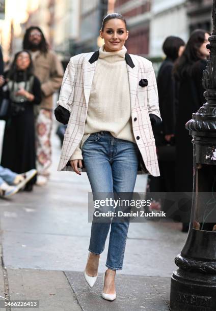 Olivia Palermo is seen wearing a black and white checkered jacket, cream sweater, blue jeans and white heels outside the Hellessy show during New...