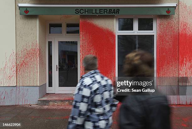 People walk past the vandalized Schillerbar in Neukoelln district on June 21, 2012 in Berlin, Germany. Five unknown assailants smashed windows and...