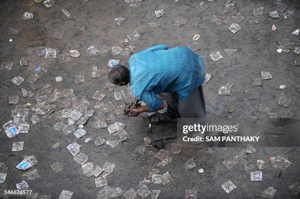 An Indian ragpicker collects discarded plastic water pouches offered free to devotees during the 135th Lord Jagannath Rath Yatra in Ahmedabad on June...