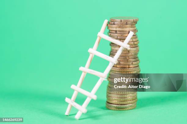 a ladder on a tower of coins: concept of price escalation (inflation) - geldpolitik stock-fotos und bilder