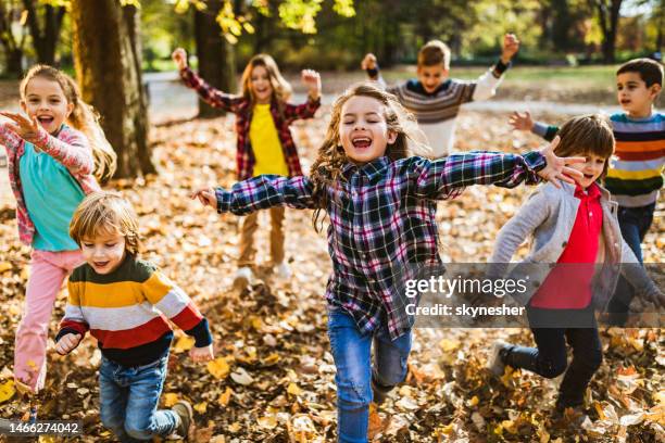 playful kids running with their arms outstretched in autumn day. - playing bildbanksfoton och bilder