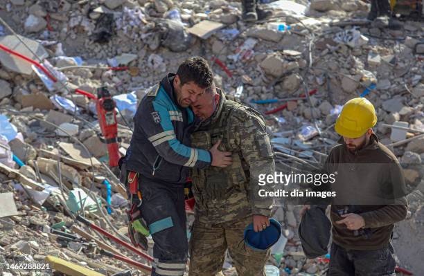 Members of the Turkish military embrace a fireman from the Ankara fire department as search and rescue operations continue on February 14, 2023 in...