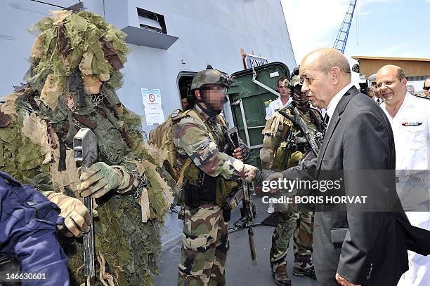 France's Defence Minister Jean-Yves Le Drian shakes hands with members of the French Navy commando Hubert during his visit on board of the French...