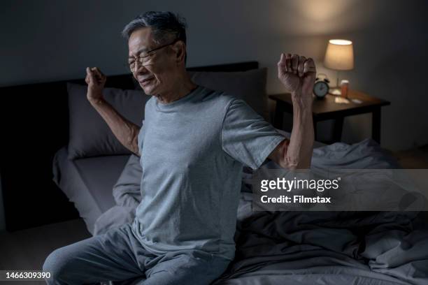 senior asian man suffering from back ache on the bed, healthcare and problem concept - back pain bed stock pictures, royalty-free photos & images