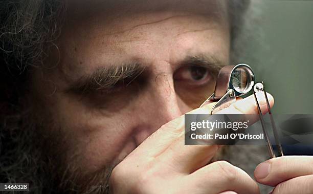 An unidentified diamond trader examines a newly polished stone at the Diamond Market October 9, 2002 in Antwerp, Belgium. Belgian Princess Mathilde...