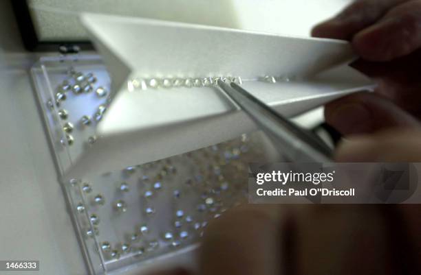 An unidentified diamond trader examines a newly polished stone at the Diamond Market October 9, 2002 in Antwerp, Belgium. Belgian Princess Mathilde...