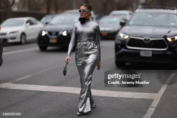 Guest seen wearing Balenciaga silver sunglasses, silver earrings, black choker necklace with a tulle flower, shiny silver turtleneck top with long...