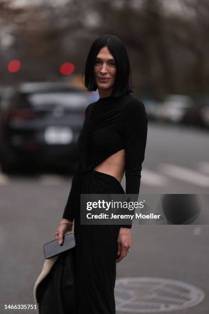 Guest wears a black ruffled long sleeves / cut-out waist / long dress, outside Jason Wu Collection, during New York Fashion Week, on February 12,...