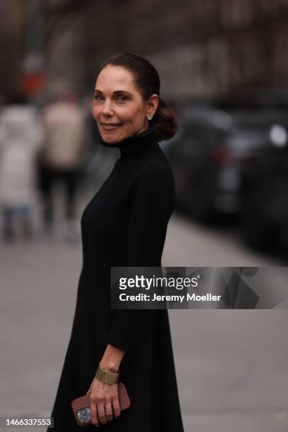 Guest seen wearing silver earrings, black turtleneck dress with long sleeves, gold bracelet, outside Jason Wu Collection, during New York Fashion...