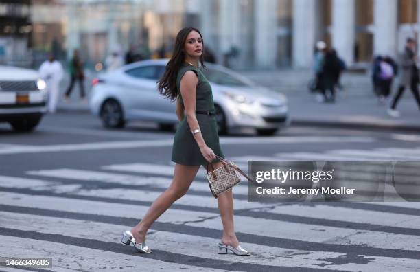 Andrea Sabotic seen wearing Tory Burch gold necklace, silver bracelet, Tory Burch grey sleeveless short dress, Tory Burch black leather belt with a...