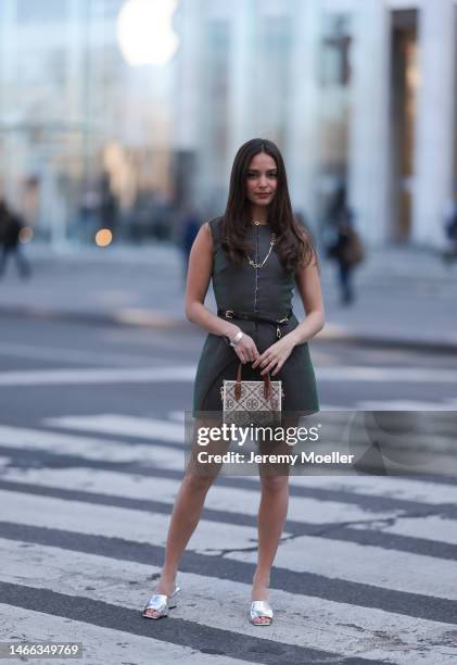 Andrea Sabotic seen wearing Tory Burch gold necklace, silver bracelet, Tory Burch grey sleeveless short dress, Tory Burch black leather belt with a...