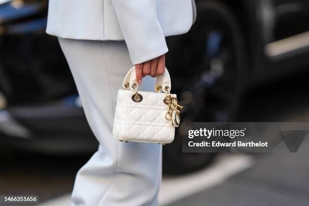 Guest wears a white blazer jacket, matching pale blue suit pants, a white latte leather Lady D-Light handbag from Dior , outside Brandon Maxwell,...