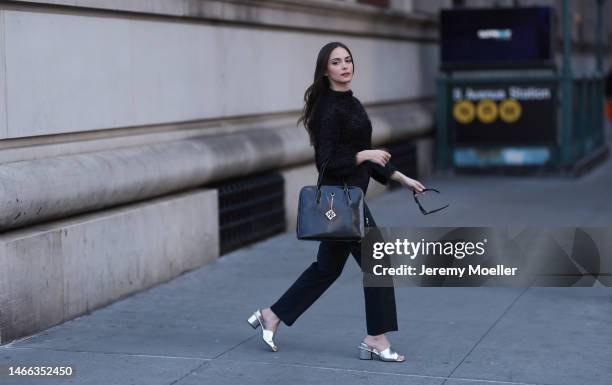 Andrea Sabotic seen wearing Ferragamo black sunglasses, Tory Burch black fluffy glitter pullover / sweater, Karl Lagerfeld black suit pants, Tory...